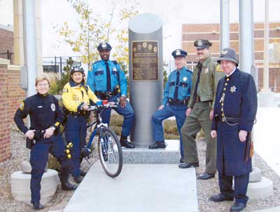 Photo of time capsule surrounded by officers wearing various SPPD uniforms